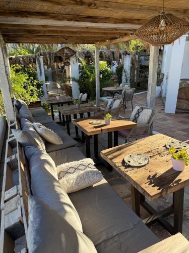 eine Außenterrasse mit Holztischen und Bänken in der Unterkunft Buenavista & Suites in Santa Eulària des Riu