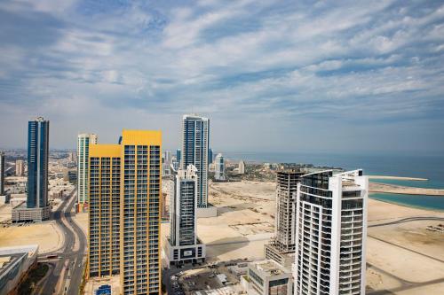 an aerial view of a city with tall buildings at Hilton Bahrain City Centre Hotel & Residences in Manama