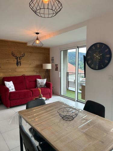 - un salon avec un canapé rouge et un réveil dans l'établissement Résidence Miselle 4 personnes, à Gérardmer