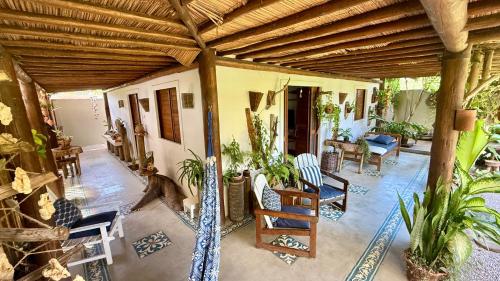a porch with chairs and a wooden roof at Bangalô de Charme na Praia do Patacho - Rota Ecológica dos Milagres in Pôrto de Pedras