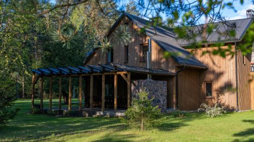 a large wooden barn with a gambrel roof at River Mind Villa with SPA in Zalioji