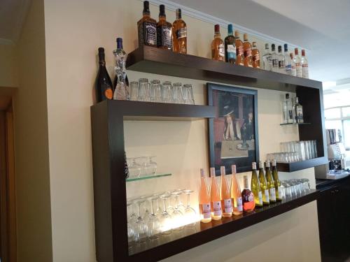 a shelf with bottles and glasses on a wall at Mateus Hotel & Pool in Jounieh