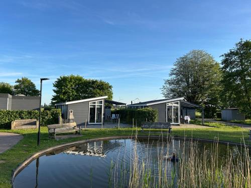 a house with a pond in front of it at Mayas Ferienhaus in Lathum