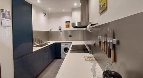 une cuisine avec un évier et une machine à laver dans l'établissement Burdigala Homes - L'Appart Place du Palais, à Bordeaux