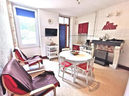 un salon avec une table et des chaises et une cuisine dans l'établissement Appartement dans maison familiale, à Luchon