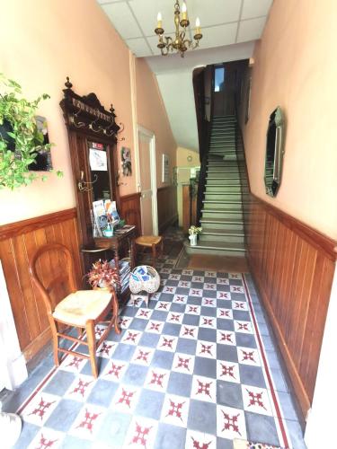 un couloir avec un escalier et du carrelage. dans l'établissement Appartement dans maison familiale, à Luchon