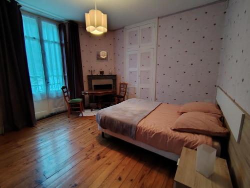 une chambre avec un lit et une table dans une pièce dans l'établissement Appartement dans maison familiale, à Luchon