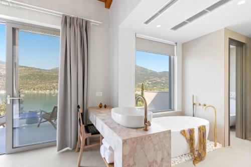 a bathroom with a tub and a large window at Villa Aenya in Yenion