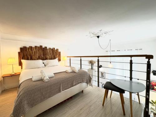 une chambre avec un grand lit et une table dans l'établissement La Loge Urbaine - Cœur de Ville, à Avignon