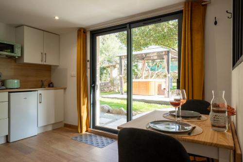 - une cuisine avec une table et un verre de vin dans l'établissement Ô Jacuzzi du Mazet, à Murles