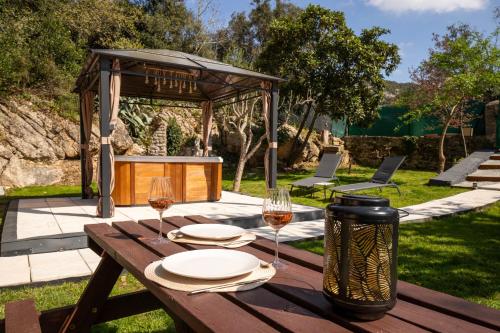 a wooden table with two glasses of wine at Ô Jacuzzi du Mazet in Murles