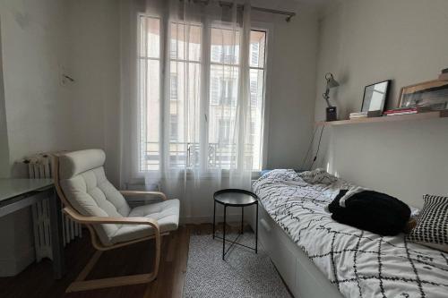une chambre avec un lit, une chaise et une fenêtre dans l'établissement Lovely studio for 2 near Montmartre, à Paris