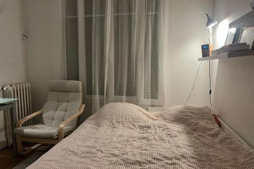 - une chambre avec un lit et une chaise à côté d'une fenêtre dans l'établissement Lovely studio for 2 near Montmartre, à Paris