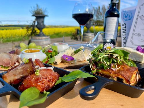 a table with a plate of food and a glass of wine at Sydkustens at Pillehill in Skivarp