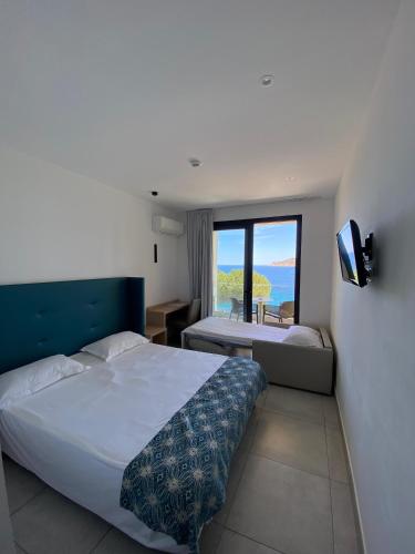 une chambre avec un lit et une vue sur l'océan dans l'établissement Hotel Restaurant Le Filosorma, à Galéria