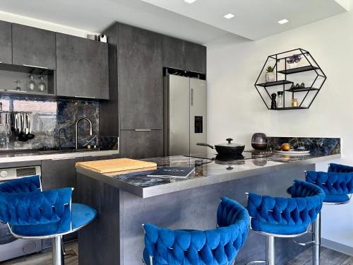 une cuisine avec des chaises bleues à un comptoir dans l'établissement Le Patio Bleu, à Vallauris