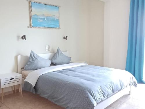 a white bedroom with a bed with blue curtains at FLORA STUDIOS CORFU - Adults only in Benitses