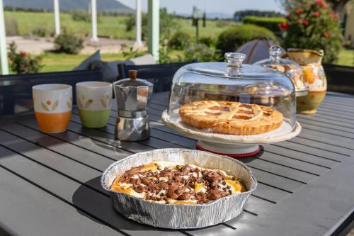 a table with a pie in a pan and a cake at Bioagriturismo Terra d'Angeli in Bagno Roselle