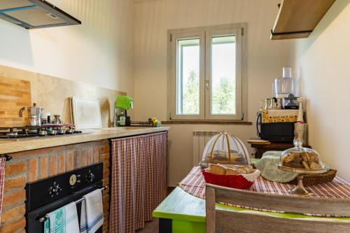 a kitchen with a table and a stove top oven at Bioagriturismo Terra d'Angeli in Bagno Roselle