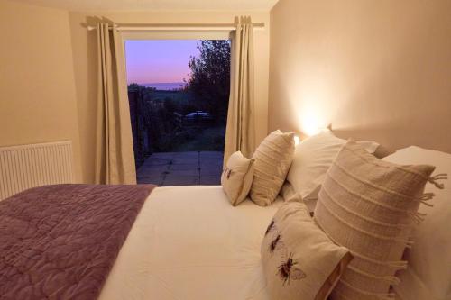 a bed with pillows and a window with a view at Hunters Lodge Inn in Totnes