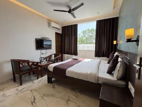 a bedroom with a bed and a desk and a television at Hotel Casa in Chandīgarh