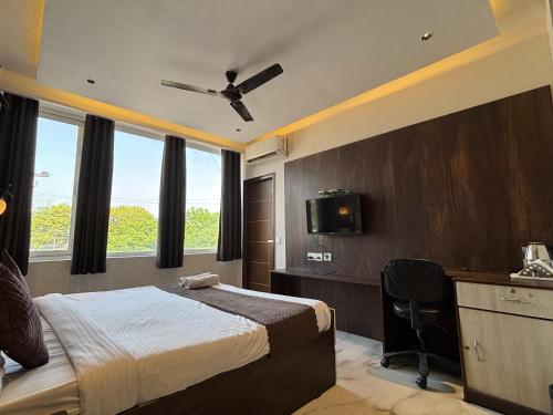 a bedroom with a bed and a desk and a television at Hotel Casa in Chandīgarh