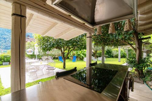 a patio with a wooden table and a view of a park at Gritti Palace Morcote - Waterfront studio with panoramic lake views - Fiordaliso in Morcote