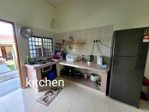 a kitchen with a sink and a refrigerator at Pangkor Homestay in Pangkor