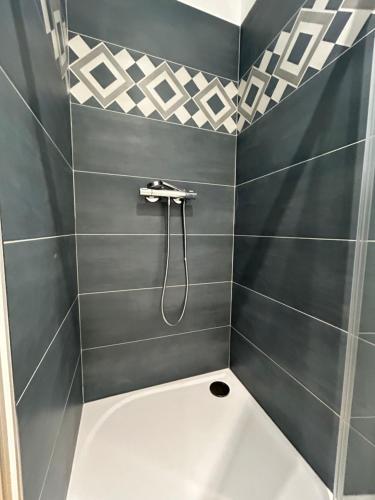 a bathroom with a shower with black and white tiles at Studio cosy in Frontignan