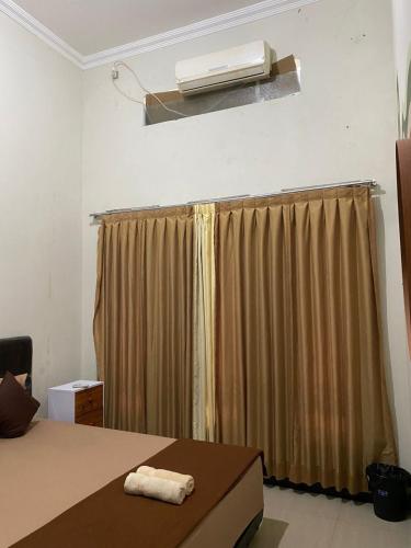 a bedroom with a bed and a window with a heater at Zzz Hostel Malang in Malang