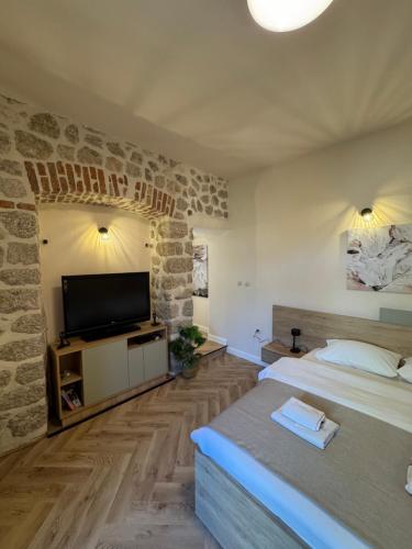 a bedroom with two beds and a flat screen tv at Apartments Marilu in Kotor