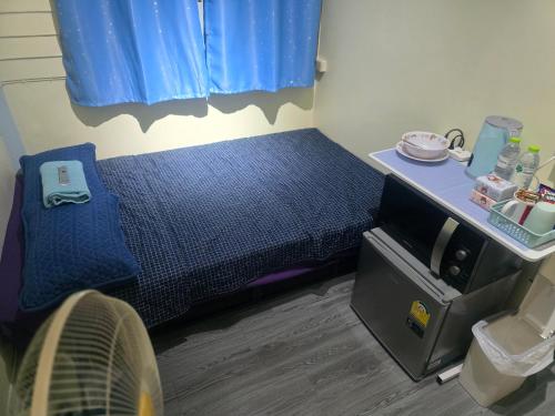 a small bed in a room with a fan at 209 Cozy apartment with nice fan near skytrain & WiFi in Bangkok