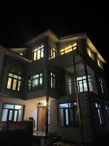 a large building with many windows at night at Al Mubeen home stay in Nishāt