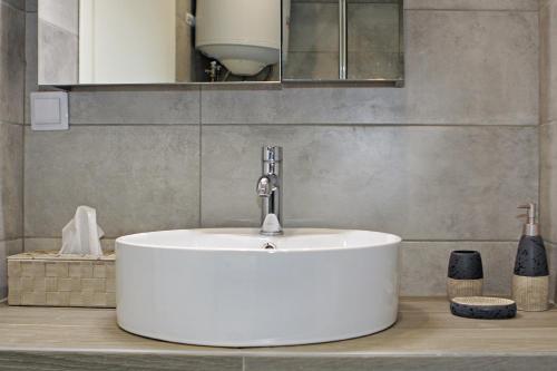 a bathroom with a white sink with a faucet at Luxury apartment in sithonia in Neos Marmaras
