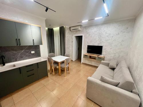 a living room with a couch and a table and a tv at Kamberi Hotel & Apartments in Velipojë