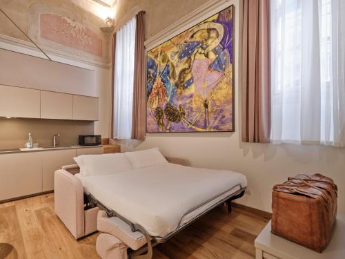 a hospital room with a bed and a painting on the wall at Palazzo Del Carretto-Art Apartments and Guesthouse in Turin