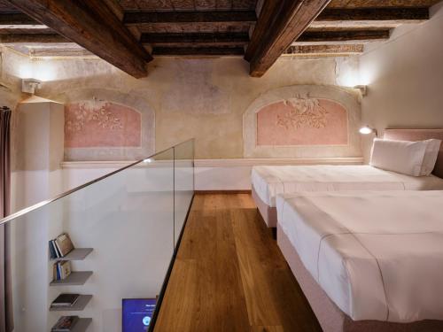 a room with two beds and a glass table at Palazzo Del Carretto-Art Apartments and Guesthouse in Turin
