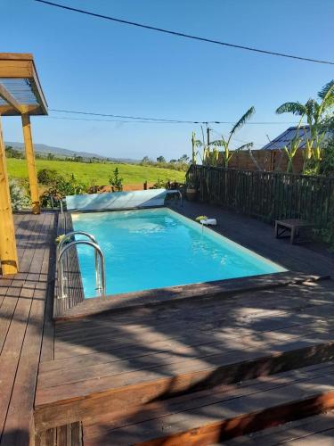 a small swimming pool with a wooden deck at La case d'Édith in Le Tampon