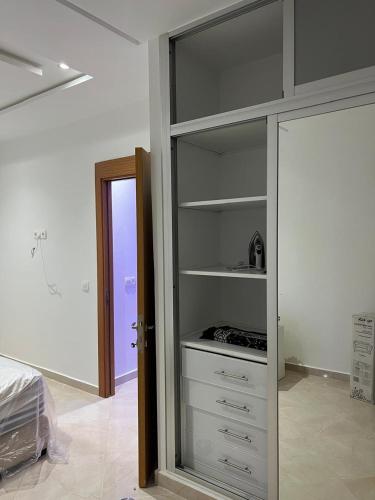 a bedroom with a white closet with a glass door at Rimal Costa Martil in Martil