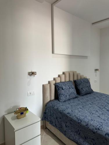 a bedroom with a bed with a blue comforter at Rimal Costa Martil in Martil