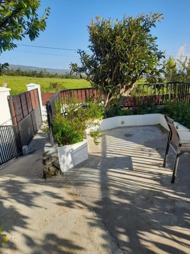 a bench sitting on a sidewalk next to a fence at La case d'Édith in Le Tampon