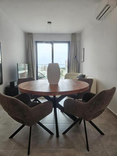 a dining table and chairs in a living room at Sea view Penthouse Universal Residences in Nea Paphos