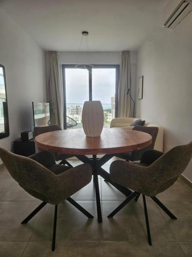 a dining table and chairs in a living room at Sea view Penthouse Universal Residences in Nea Paphos