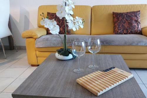 - un salon avec une table et deux verres à vin dans l'établissement Cosy seaside apartment with a pool, à Antibes