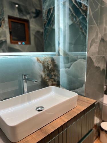 a bathroom with a white sink and a mirror at Kamberi Hotel & Apartments in Velipojë
