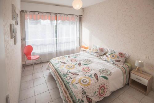 - une chambre avec un lit, une fenêtre et une chaise rouge dans l'établissement Beautiful apartment 82m2, WiFi, Air conditioning, sea view & pool & tennis, à Antibes