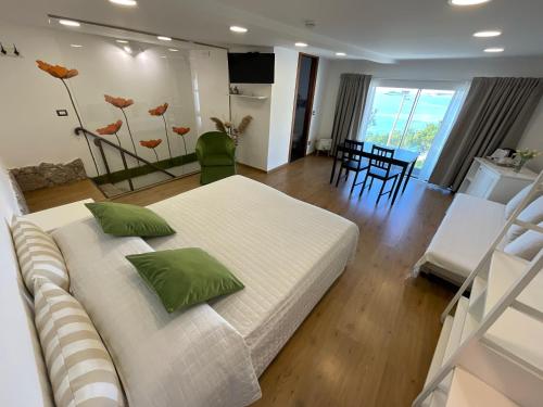 a bedroom with a large white bed with green pillows at BellaVista in Taormina