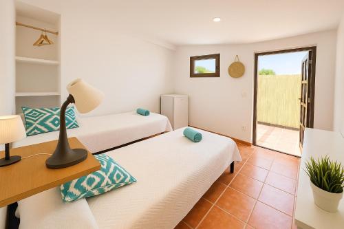 une chambre avec deux lits et un balcon dans l'établissement Habitación en el campo con baño privado en Puerto Pollensa, à El Port