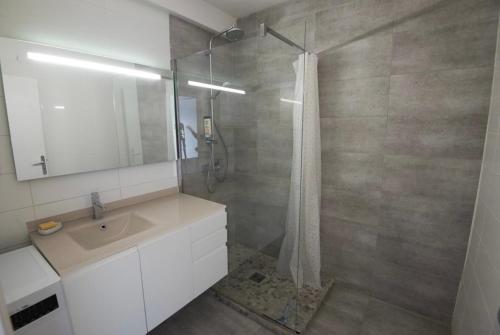 une salle de bain blanche avec un lavabo et une douche dans l'établissement Beautiful apartment 82m2, WiFi, Air conditioning, sea view & pool & tennis, à Antibes