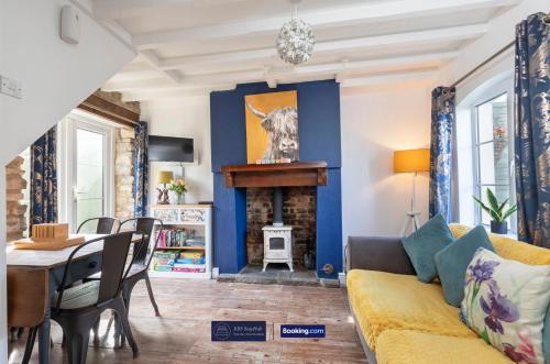 ein Wohnzimmer mit einem gelben Sofa und einem Kamin in der Unterkunft Pet Friendly Cottage By KBS Stayhub Short Lets & Serviced Accommodation Stonehouse With Log Fire, Parking in Gloucestershire